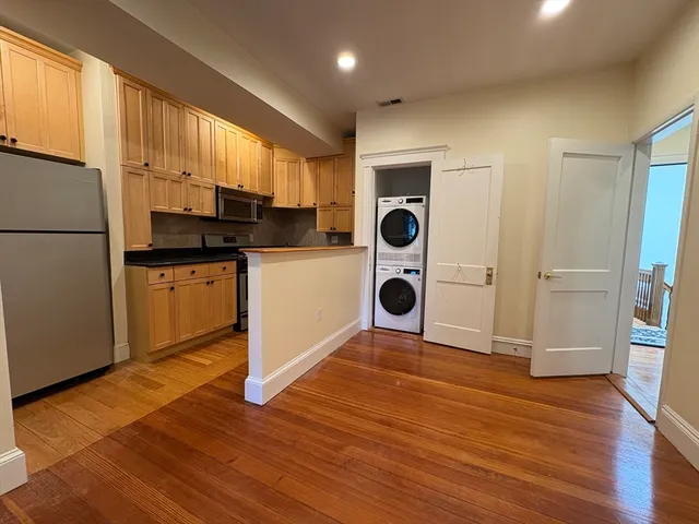a kitchen with a sink a refrigerator and cabinets