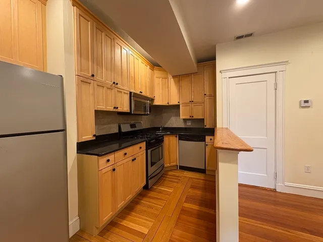 a kitchen with stainless steel appliances a refrigerator sink and cabinets