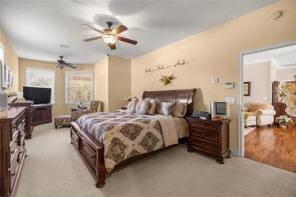 a spacious bedroom with a bed and a chandelier