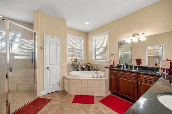 a large bathroom with a tub sink and mirror