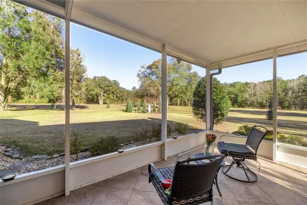 a view of a chairs and table in patio with a yard