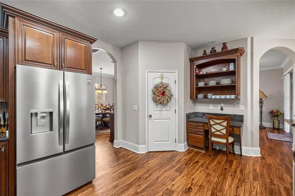 a kitchen with stainless steel appliances granite countertop a refrigerator and a stove top oven