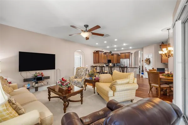 a living room with furniture kitchen view and a flat screen tv