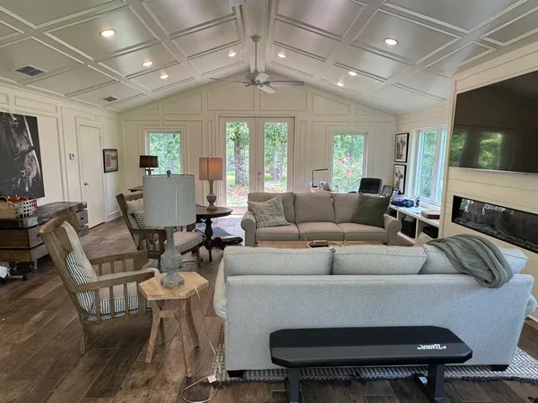 a living room with furniture a flat screen tv and a window