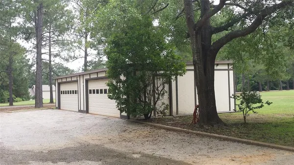 a view of a house with a yard and large tree