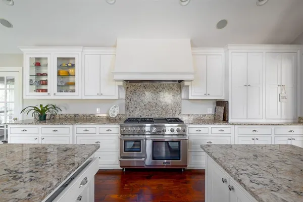 a kitchen with stainless steel appliances granite countertop a sink stove and cabinets