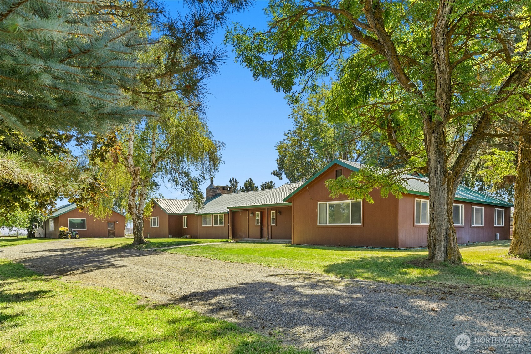 a front view of a house with a garden and trees