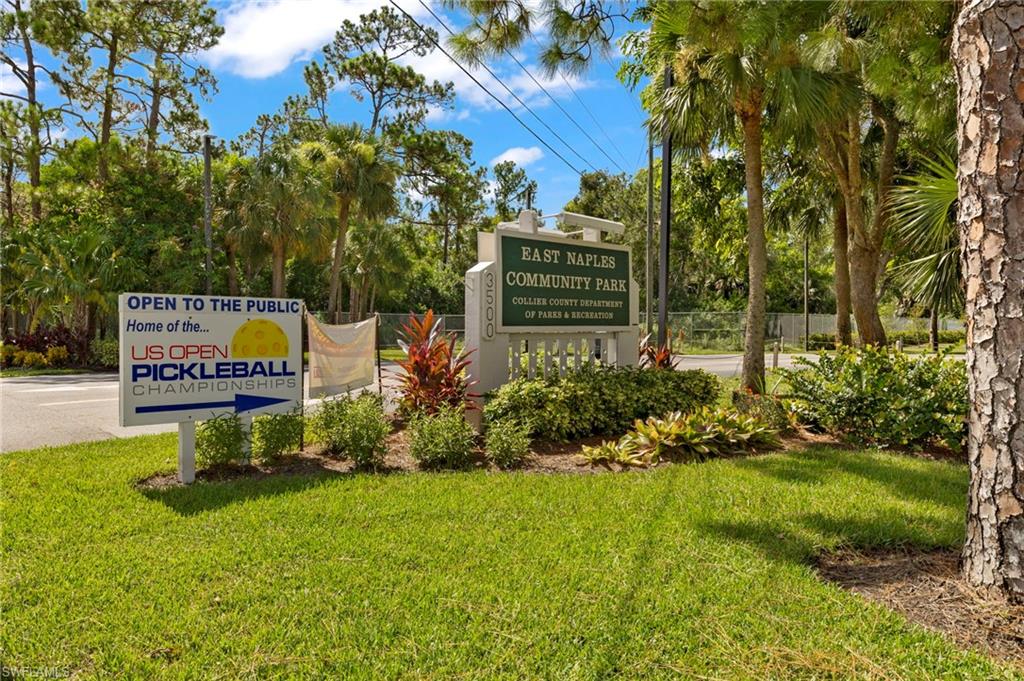 4718 Normandy Drive Naples, FL 34112 - Photo 11 of 14 a sign board with flower plants and big trees