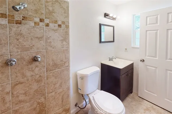 a bathroom with a toilet a sink a vanity and mirror