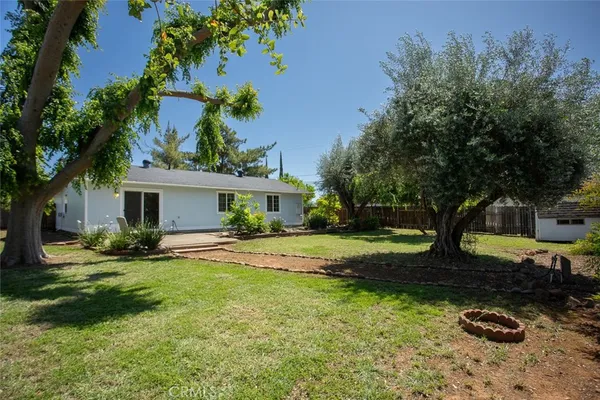 a view of a house with backyard and a tree