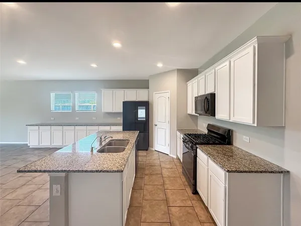 a kitchen with granite countertop counter top space a sink stainless steel appliances and cabinets