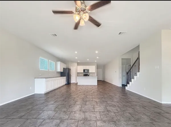 a view of a livingroom with a ceiling fan and window