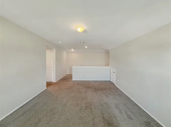 a view of a big room with wooden floor and windows