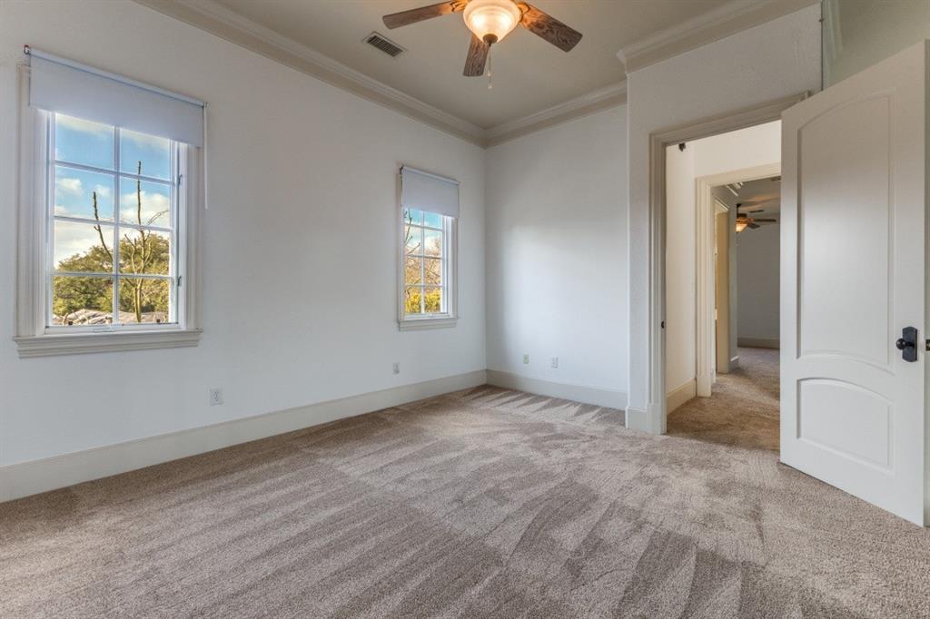 6416 Dykes Way Dallas, TX 75230 - Photo 20 of 37 an empty room with windows and chandelier fan