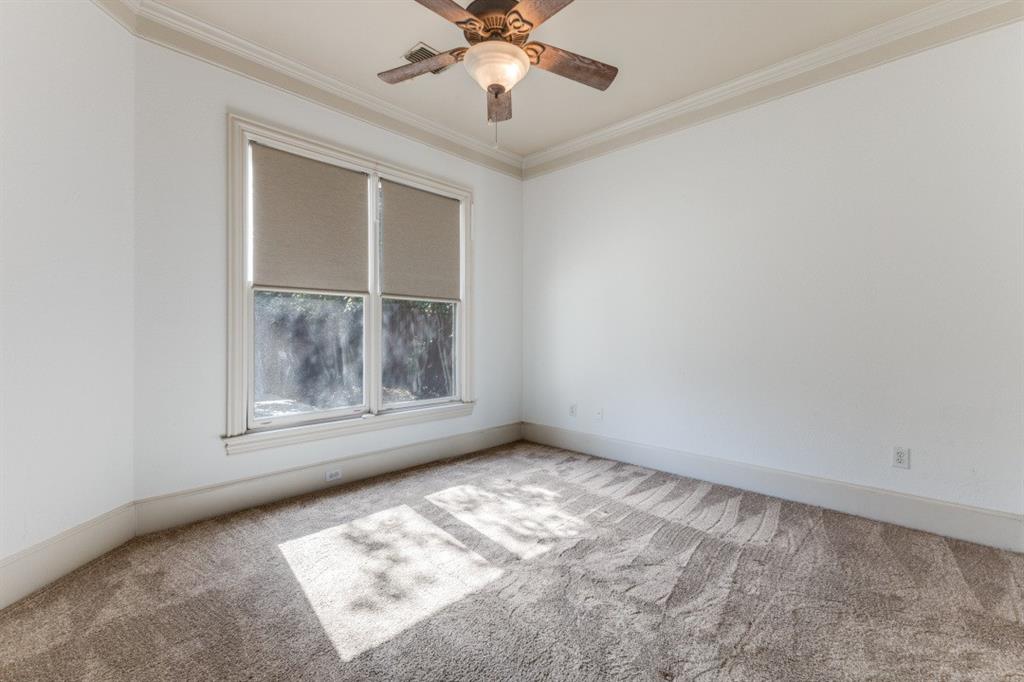 6416 Dykes Way Dallas, TX 75230 - Photo 24 of 37 an empty room with a chandelier fan and windows