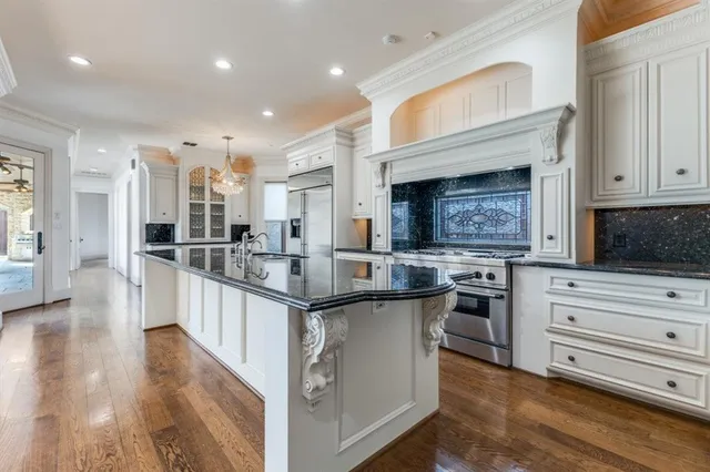 a kitchen with stainless steel appliances granite countertop a lot of counter space and wooden floor