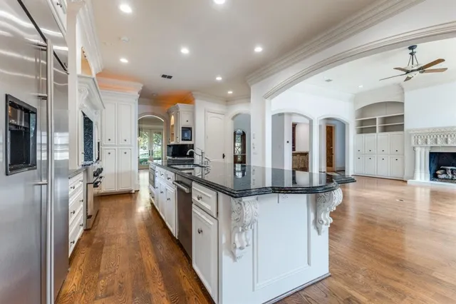 a kitchen with stainless steel appliances granite countertop lots of counter top space and wooden floor