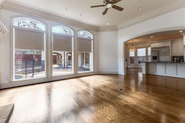 a view of an empty room with a window and kitchen view