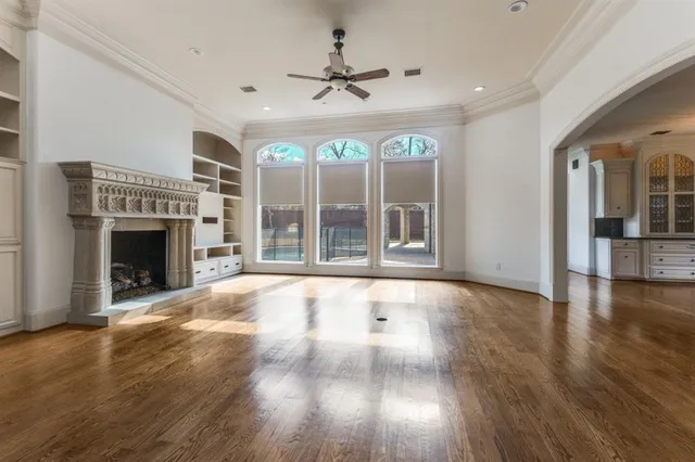 an empty room with floor fireplace and windows