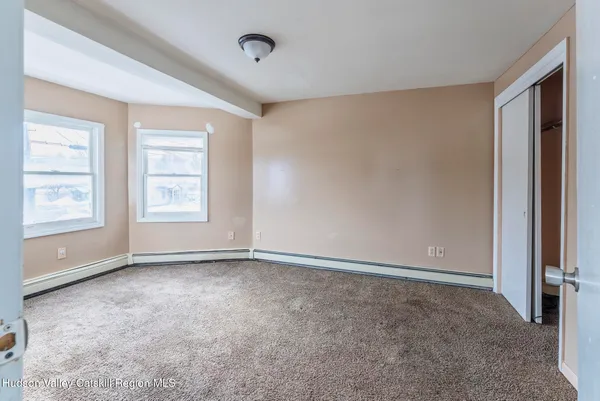 an empty room with windows and closet
