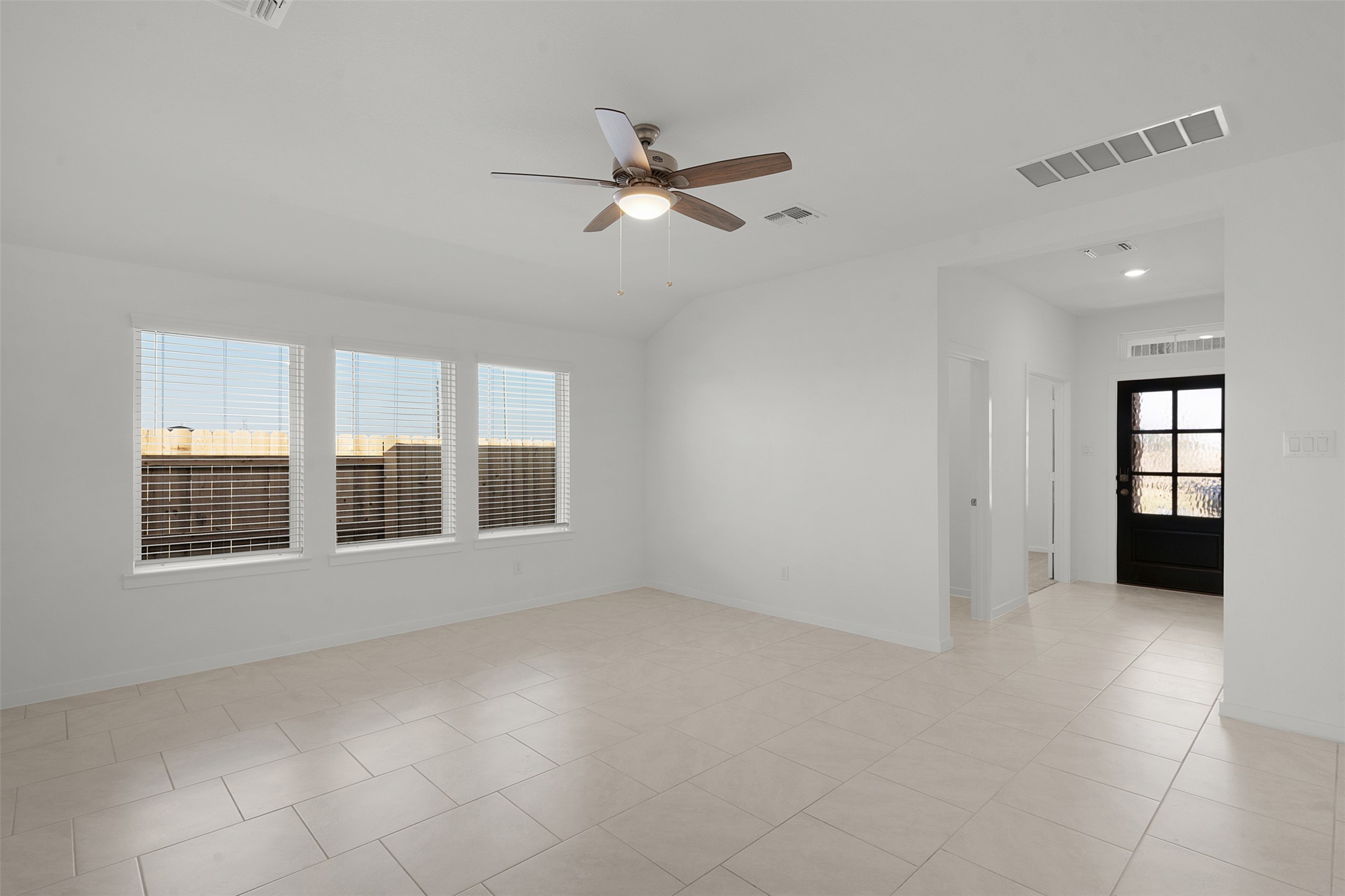 13832 Scarlett Song Drive Elgin, TX 78621 - Photo 5 of 26 Unfurnished room with ceiling fan, light tile patterned flooring, and vaulted ceiling