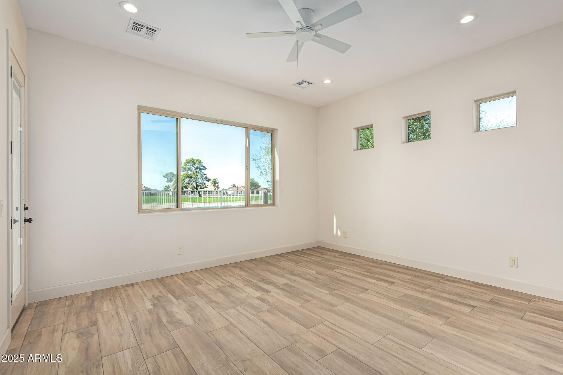 14730 South Rory Calhoun Road Arizona City, AZ 85123 - Photo 13 of 43 an empty room with wooden floor fan and windows