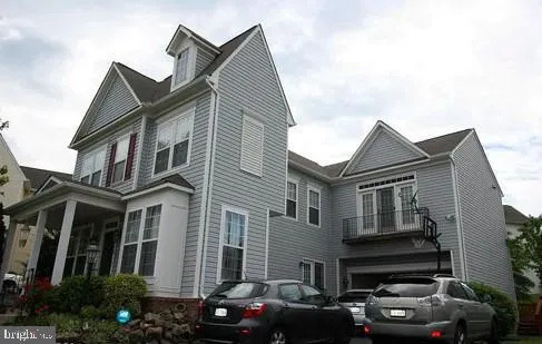 a front view of a house with cars parked