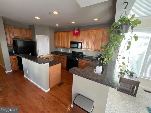 a kitchen with a sink a counter top space and living room area