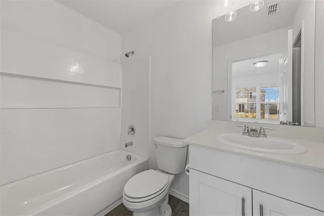 a bathroom with a sink toilet vanity and shower