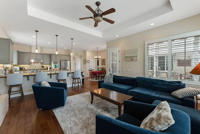 a living room with furniture kitchen view and a large window