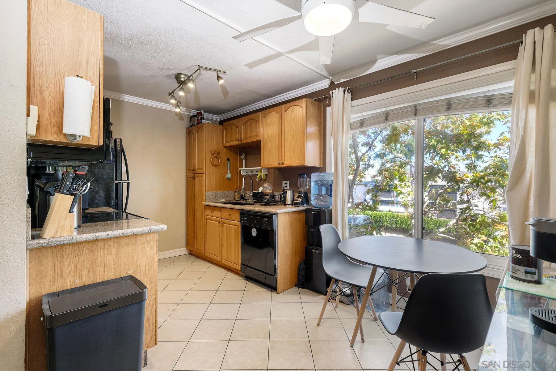 12923 Mapleview Street, Unit 6 Lakeside, CA 92040 - Photo 9 of 25 a kitchen with a table chairs microwave and cabinets