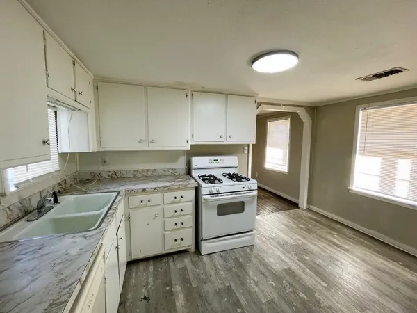 a kitchen with a stove sink and cabinets
