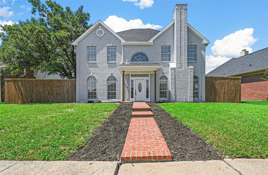 a front view of a house with a yard and potted plants