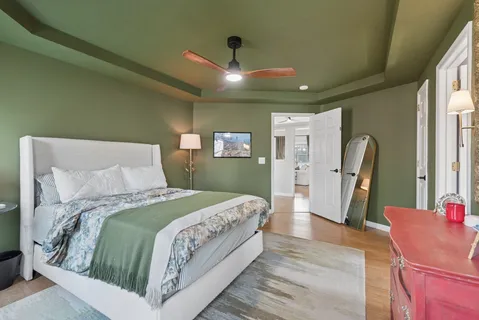 a bedroom with a large bed and a chandelier