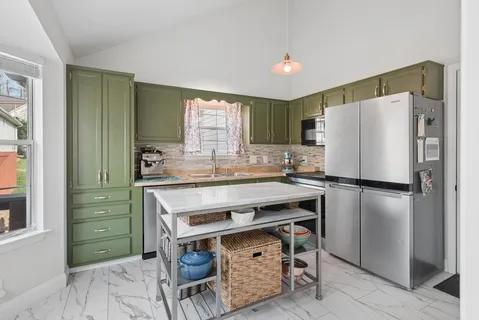 a kitchen with a refrigerator a sink and a stove top oven