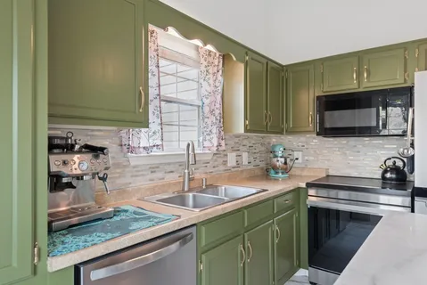 a kitchen with sink a microwave and cabinets
