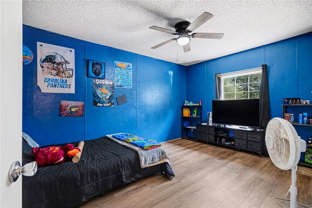 1004 Chapman Road Honea Path, SC 29654 - Photo 18 of 30 This spacious bedroom features warm wood flooring and a refreshing ceiling fan.