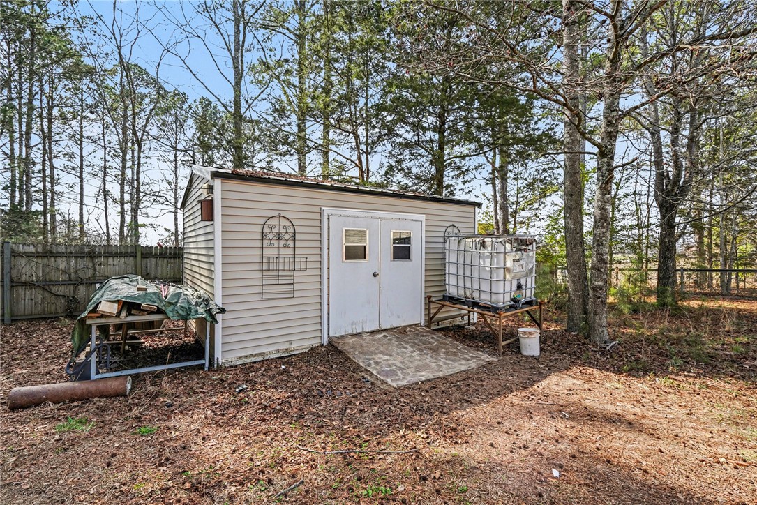 1004 Chapman Road Honea Path, SC 29654 - Photo 28 of 30 This outdoor storage shed offers practical utility amidst a natural, wooded setting.