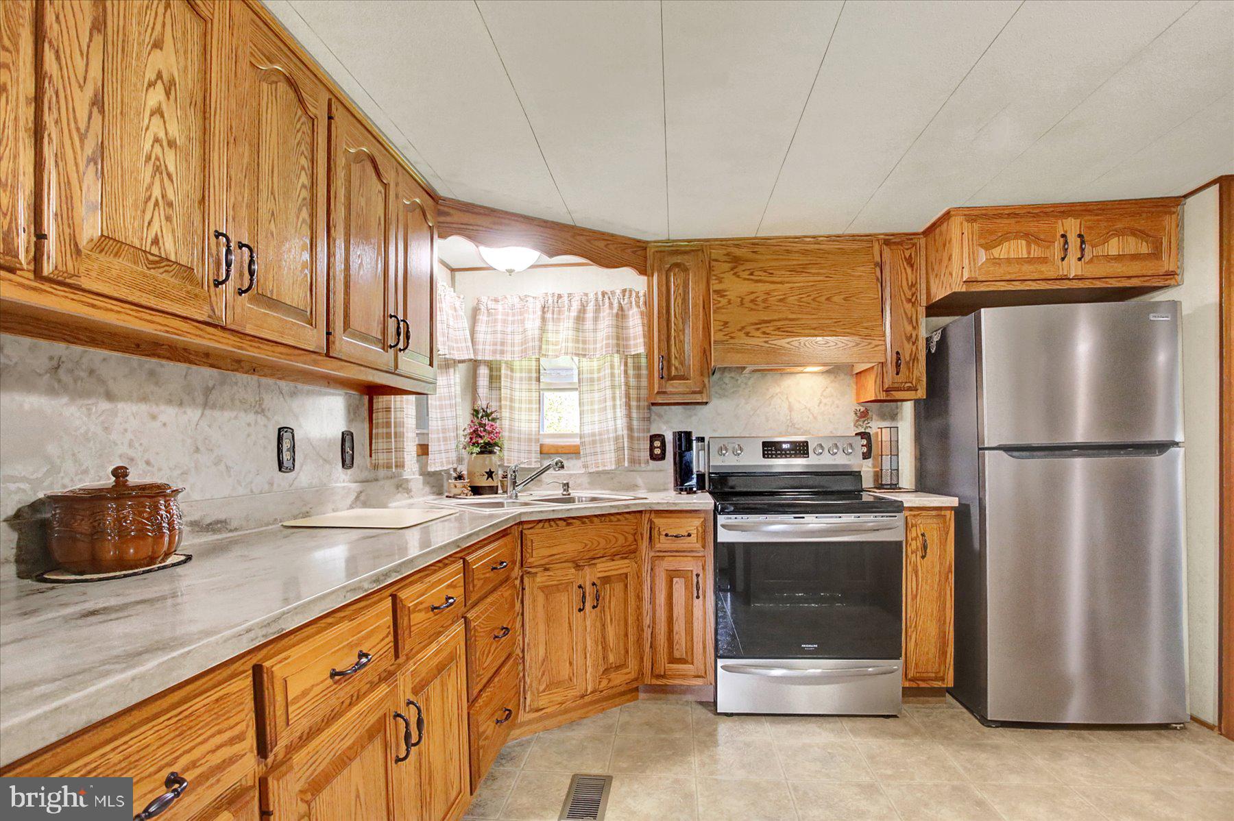 72 Cedar Grove Road Mifflintown, PA 17059 - Photo 7 of 31 a kitchen with stainless steel appliances granite countertop a refrigerator a sink dishwasher a stove and white countertops with cabinets