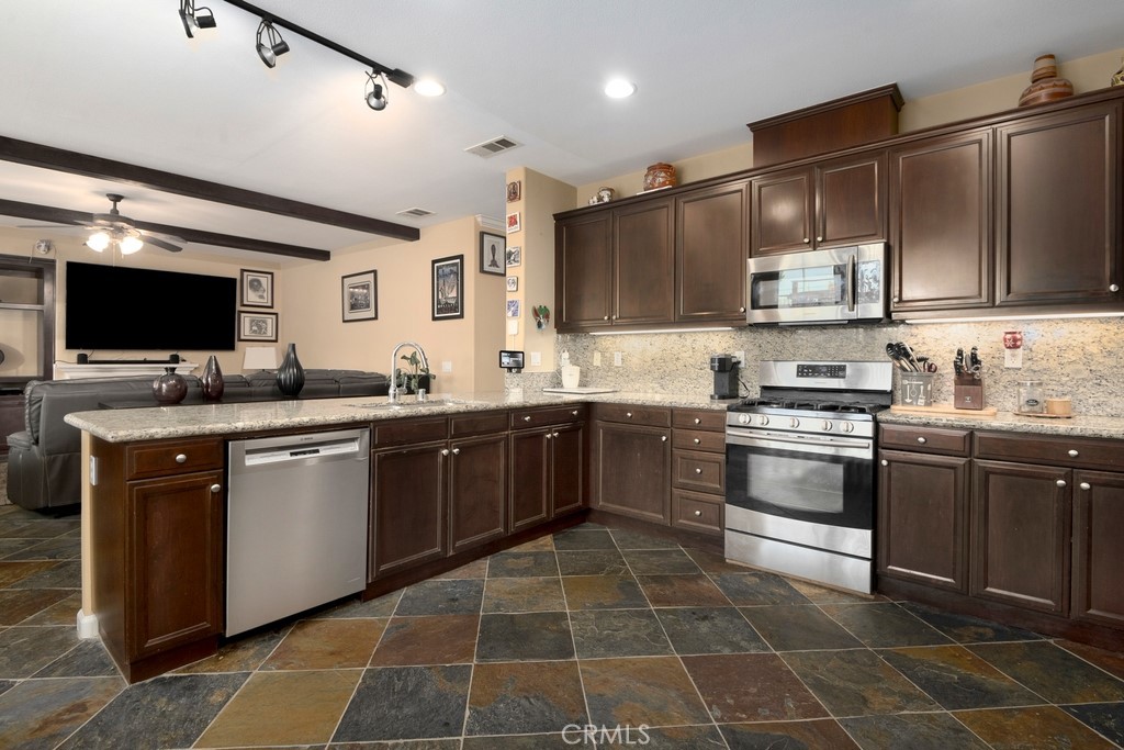 130 Daylily Drive Perris, CA 92571 - Photo 15 of 43 a kitchen with a sink cabinets and stainless steel appliances