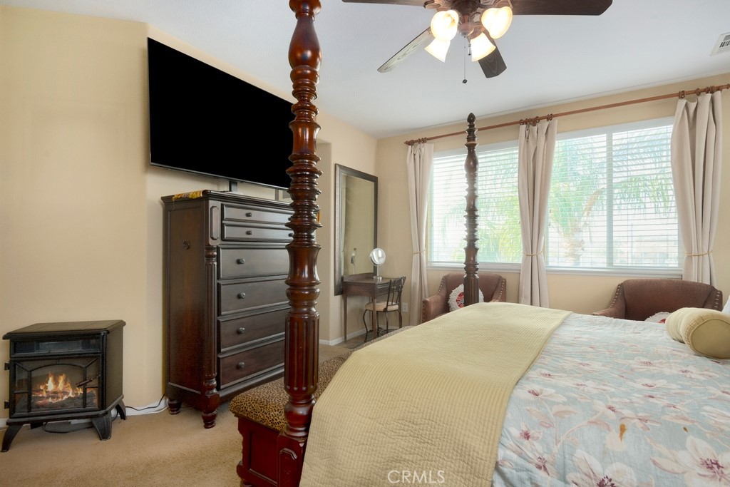 130 Daylily Drive Perris, CA 92571 - Photo 24 of 43 a bedroom with a bed and a flat tv screen on dresser