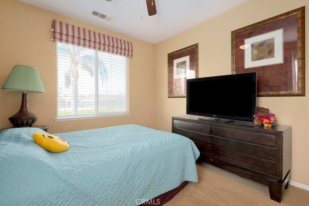 130 Daylily Drive Perris, CA 92571 - Photo 28 of 43 a bedroom with a bed and flat screen tv
