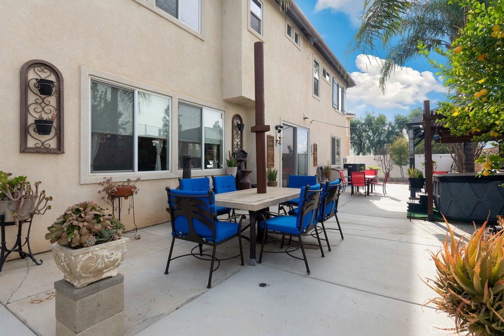 130 Daylily Drive Perris, CA 92571 - Photo 37 of 43 a view of a patio with table and chairs and potted plants