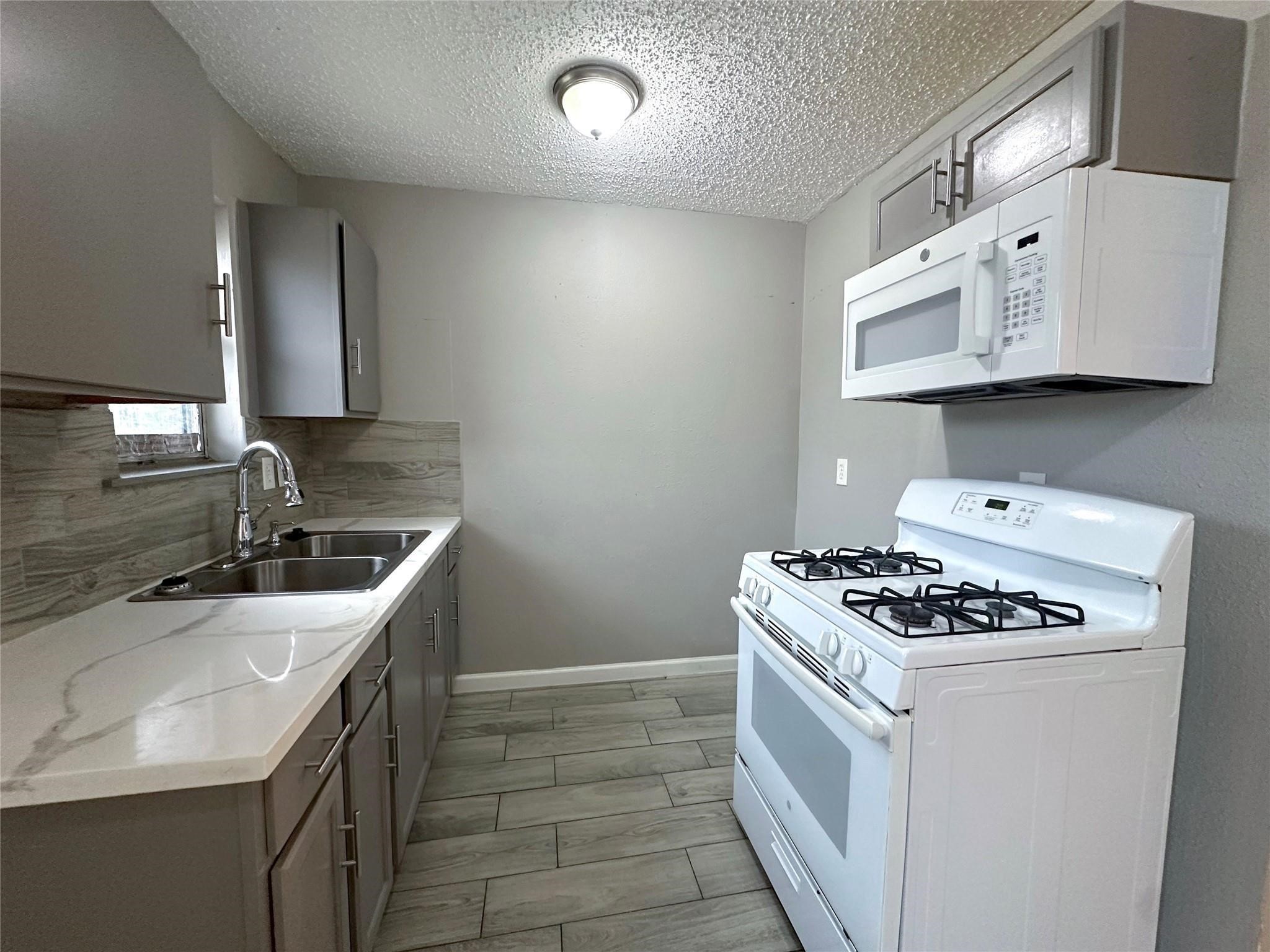 5418 Weaver Road, Unit A Houston, TX 77016 - Photo 3 of 11 a kitchen with stainless steel appliances granite countertop a sink stove and cabinets