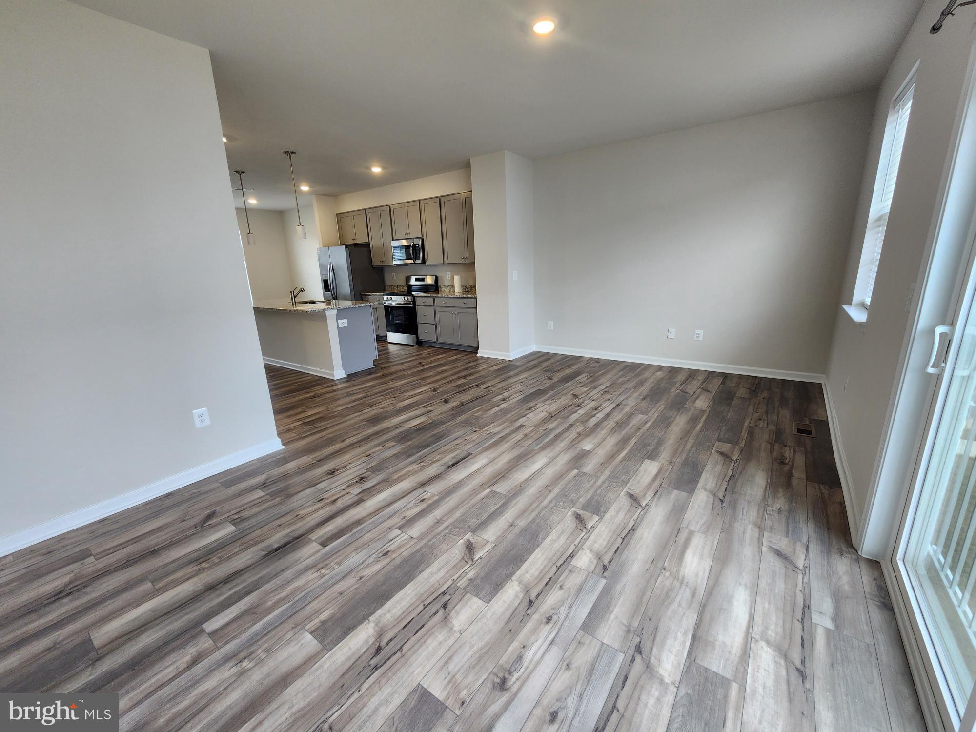 117 Canning Road Inwood, WV 25428 - Photo 17 of 41 a view of kitchen and empty room with wooden floor