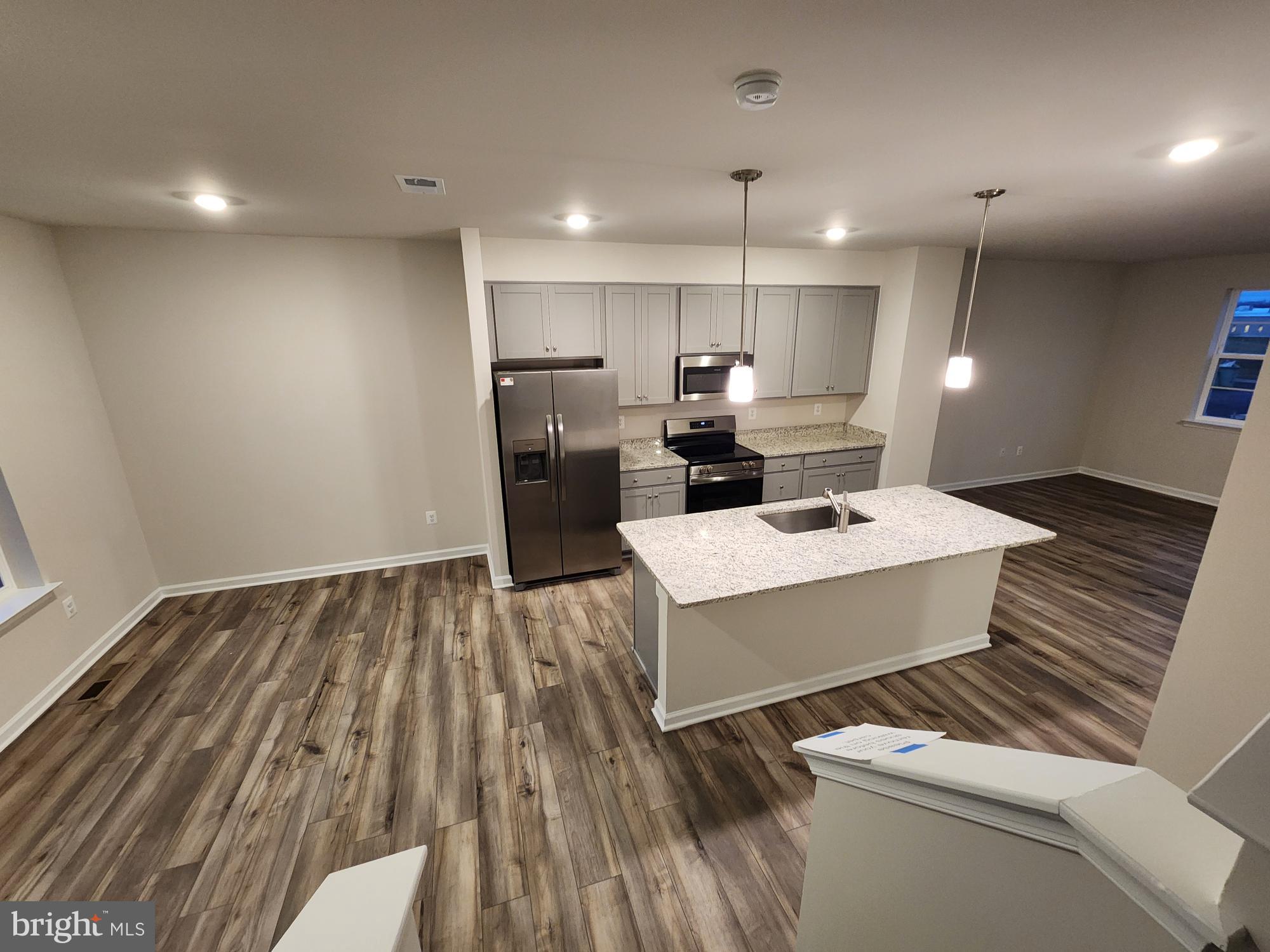 117 Canning Road Inwood, WV 25428 - Photo 6 of 41 a large white kitchen with a sink dishwasher a stove and a refrigerator with wooden floor