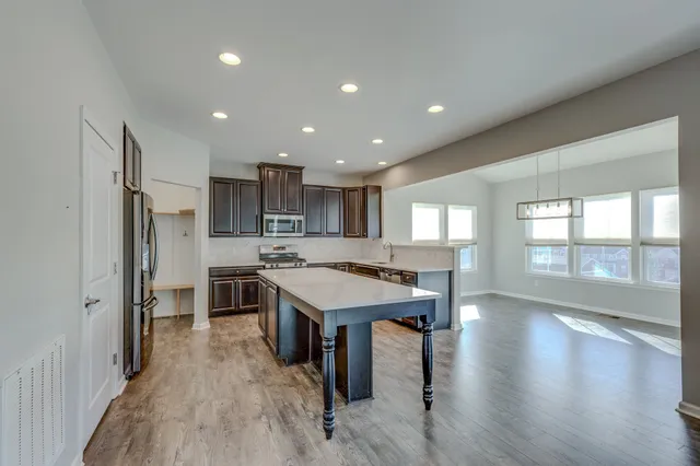 a large kitchen with a large window and stainless steel appliances