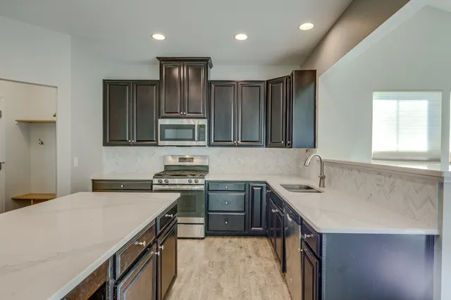 a kitchen with stainless steel appliances a sink stove and cabinets