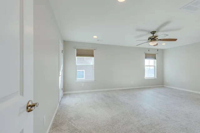 a view of a big room with chandelier fan and windows