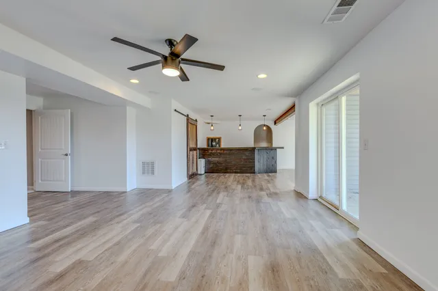 a view of a hallway with closet and wooden floor